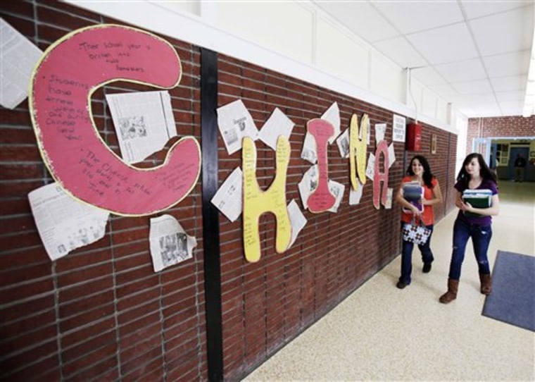 Students walk by a display about China at Stearns High School in Millinocket, Maine, on March 10. The public high school recruited students from China to help boost enrollment and revenues. But only six Chinese students will attend high school in fall 2011.